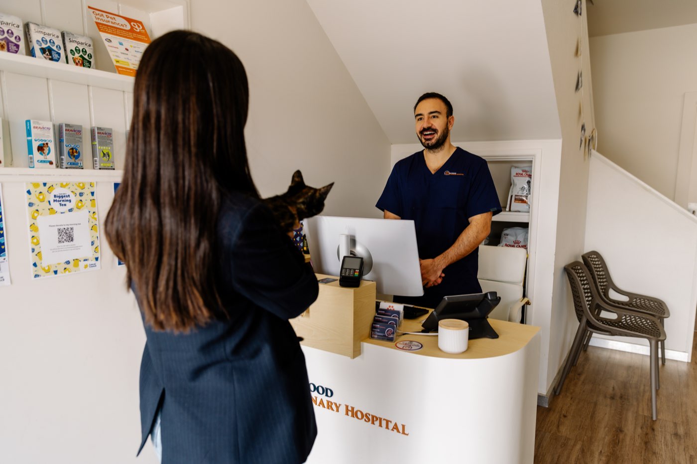 A cat in a carrier arriving at the reception desk of Eastwood Veterinary Hospital