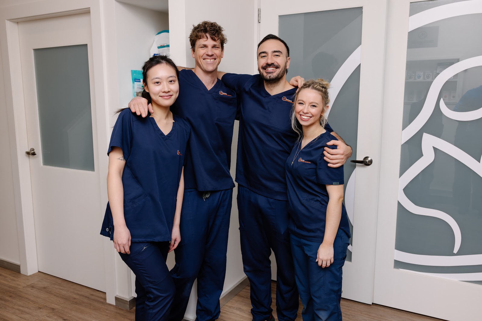 Four members of the Eastwood Veterinary Hospital team standing together in the hospital corridor